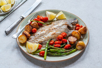 Lemon sole baked with potatoes, baby tomatoes and asparagus