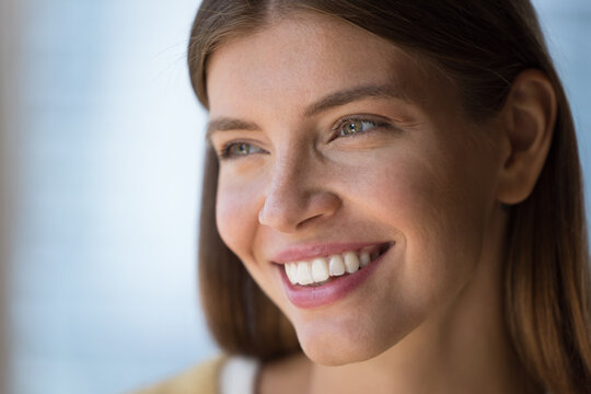 Close up candid face portrait of happy beautiful young woman with perfect white teeth, smiling, laughing, looking away, thinking, dreaming, posing. Girl promoting natural beauty