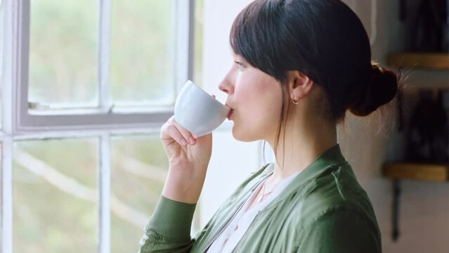 Window, coffee and thinking with a woman in her home to relax while looking at the view in the morning. Peace, idea and tea with a young female drinking a warm beverage in her house alone