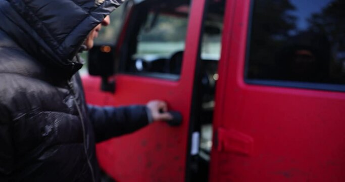 Man runs opens door of red SUV jeep
