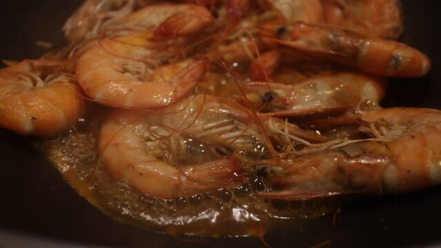 shrimps are fried in a frying pan with garlic