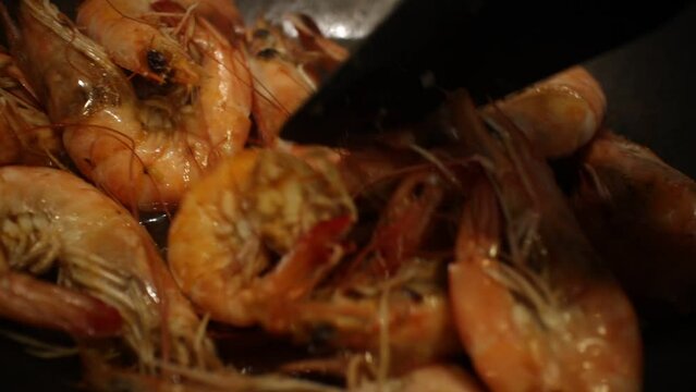 shrimps are fried in a frying pan with garlic