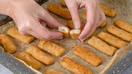 Baking pan with fish sticks close up on the kitchen table. Crunchy delicious lightly breaded with  bread crumbs fish sticks