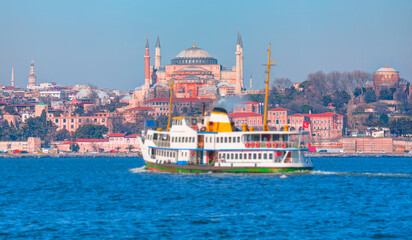 Fototapeta premium Famous historical peninsula of Istanbul - Hagia sophia, Hagia Irene Museum - Water trail foaming behind a passenger ferry boat - Bosphorus, Istanbul