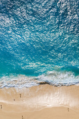 Beautiful ocean waves and white beach with people from top.