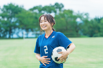 趣味でサッカー・フットサルの練習をしながら爆笑する日本人女性  © buritora