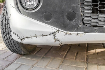 Metal rivets on a cracked car bumper.Old broken car bumper with metal wire