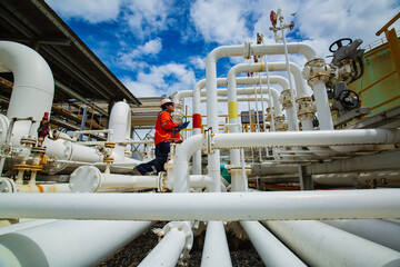 Male worker inspection at steel long pipes and pipe elbow in station flow oil factory during refinery valve of check pipeline oil