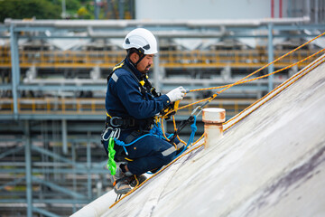Fototapeta premium Male workers clear rope access wearing safety first harness rope safety