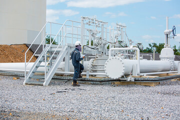 Male worker inspection at steel long pipes and pipe elbow in station oil factory during refinery valve of visual check record pipeline