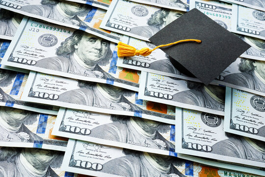 Graduation cap on the stack of money. Student loan concept.
