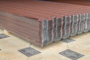 Metal profile for roof covering. Metal profiled sheeting is stored in a bundle in a warehouse for sale.