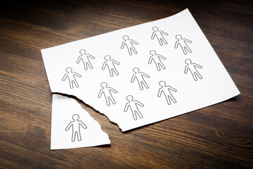 Disengaged Employees concept. Figures of people on a sheet of paper and one is torn off. - obrazy, fototapety, plakaty