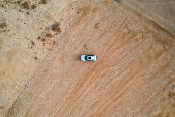 An overhead view of a vehicle in the middle of a desert landscape.