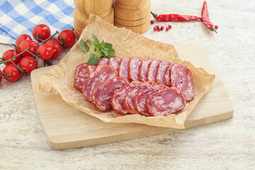 Sliced salami sausages over board