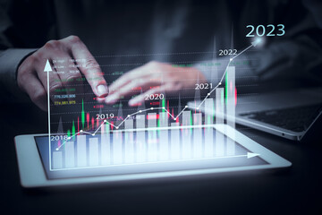 financial charts and graph analysis marketing showing growing revenue In 2023 floating above...