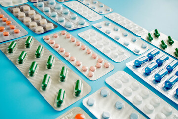 Colorful of tablets and capsules pill in blister packaging arranged with beautiful pattern with flare light. Pharmaceutical industry concept. Pharmacy drugstore