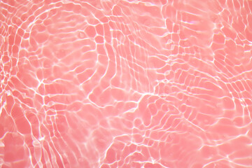 Defocus blurred transparent pink colored clear calm water surface texture with splashes and bubbles. Trendy abstract nature background. Water waves in sunlight with copy space. Pink watercolor shining