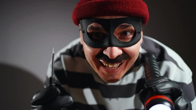 a funny burglarin mask and Prison Uniform picks the lock pick