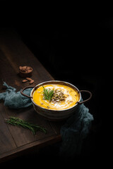 a pumpkin soup on edge dark rustic wood table