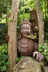 handgeschnitzte Buddhastatuen aus Holz auf Tempelgeländer in Thailand