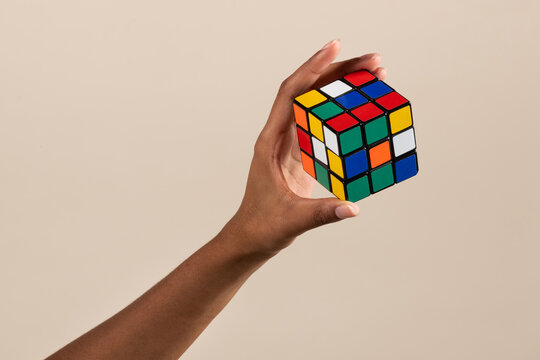 Faceless woman showing unsolved Rubik cube