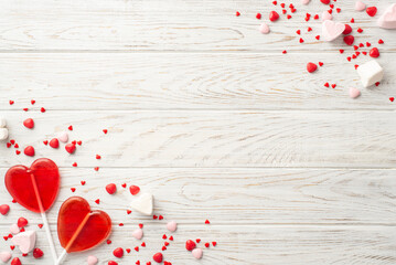 Valentine's Day celebration concept. Top view photo of heart shaped lollipops and candies on white...