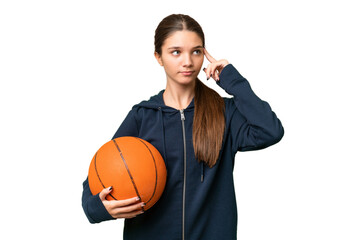 Teenager caucasian girl playing basketball over isolated background having doubts and thinking