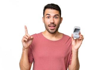 Young handsome caucasian man holding a engagement ring over isolated background pointing up a great idea