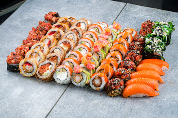Big set of sushi rolls and nigiri with tuna, salmon, shrimp, avocado, cream cheese, red flying fish caviar, seaweed and sesame.