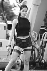 Lara Croft Tomb Raider action movie cosplay costume photoshoot with guns and weapons brunette female model Black and white version	
