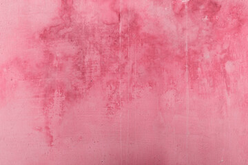 Viva Magenta. The texture of an old concrete wall with yellow divorces from the water. Grunge background. Rough, damaged, vintage plaster. The image is colored in viva magenta color of the year 2023
