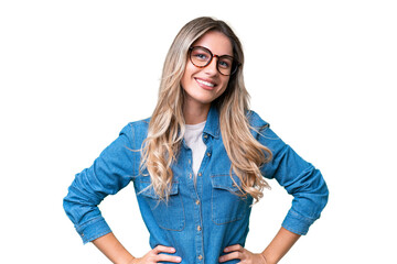 Young Uruguayan woman over isolated background posing with arms at hip and smiling