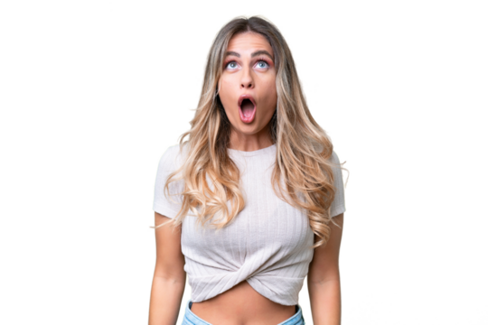 Young Uruguayan woman over isolated background looking up and with surprised expression