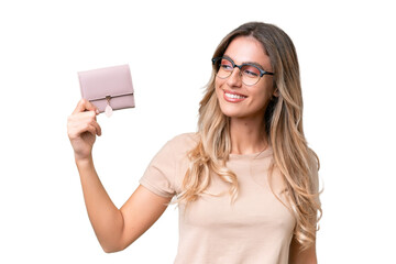 Young Uruguayan woman holding a wallet over isolated background with happy expression