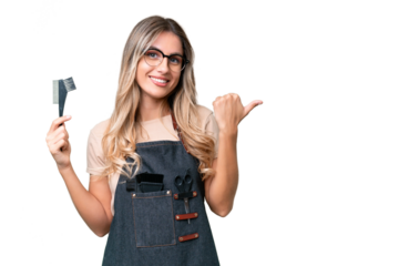 Young Uruguayan hairdresser woman over isolated background pointing to the side to present a product