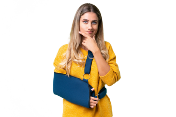 Young Uruguayan woman with broken arm and wearing a sling over isolated background thinking