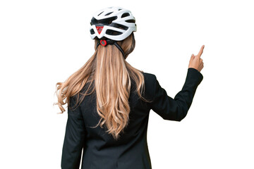 Business Uruguayan woman wearing a helmet biker over isolated background pointing back with the index finger