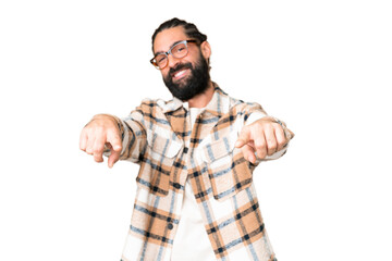 Young man with beard over isolated chroma key background points finger at you while smiling