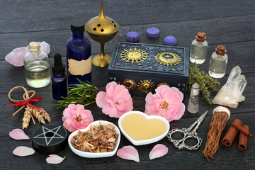 Obraz na płótnie Canvas Pagan love potion aphrodisiac recipe ingredients with herbs, rose flowers, corn dolly, oil, spring water and quartz crystals. Mystical wiccan, shamanic concoction for lovers, fertility and impotence. 