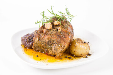 Roast pork loin with onions and garlic, decorated with rosemary and some colorful peppercorns