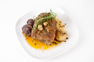 Roast pork loin with onions and garlic, decorated with rosemary and some colorful peppercorns