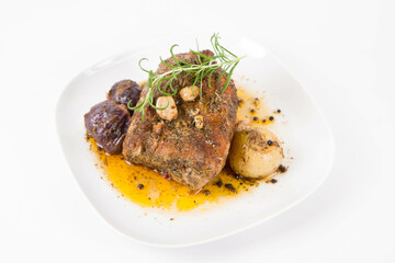 Roast pork loin with onions and garlic, decorated with rosemary and some colorful peppercorns