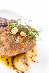 Roast pork loin with onions and garlic, decorated with rosemary and some colorful peppercorns