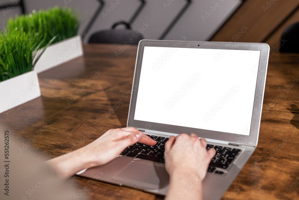 Aufkleber Laptop screen mockup and hand typing. Computer display mock up with white blank background on wood office desk