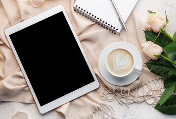 Top view a cup of coffee latte art heart shape with a pink rose and tablet