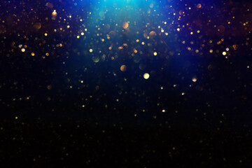 Fototapeta na wymiar background of abstract glitter lights. gold, blue and black. de focused