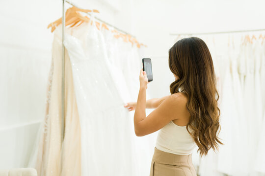 Young woman taking photos at the bridal shop