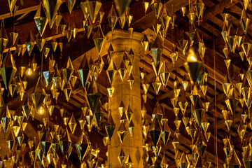 Diamonds or golden geometric shapes hanging from the wooden ceiling of the granollers porch followed as lamps of lights