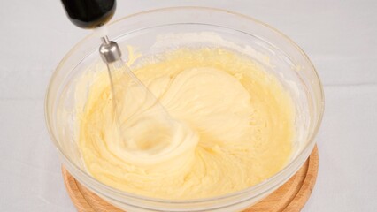 Kneading the dough with a whisk of a blender in bowl. Chef Mix liquid dough for pancakes or cake with a blender